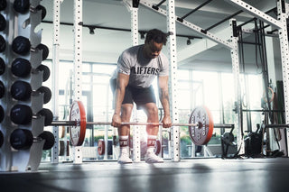 Athlet trägt weiße Lifters Sportsocken in beliebter Crew Länge und macht Kreuzheben.